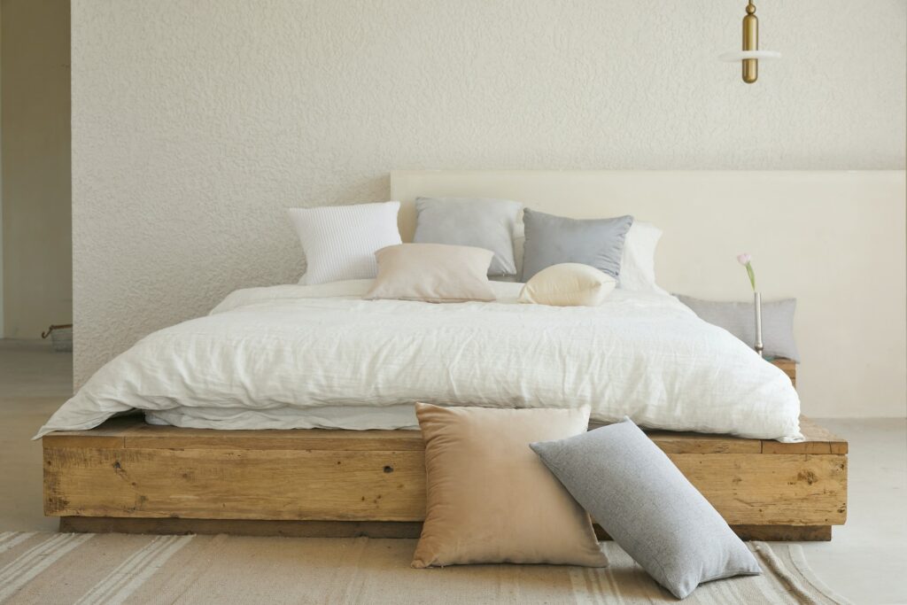 A Double Bed With A Wooden Headboard.